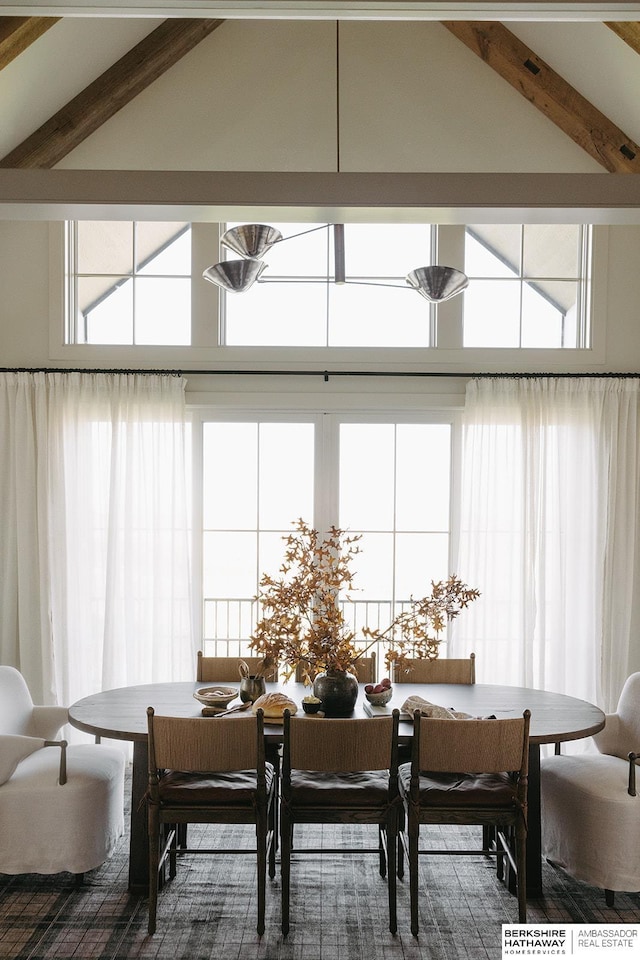 dining space featuring lofted ceiling with beams