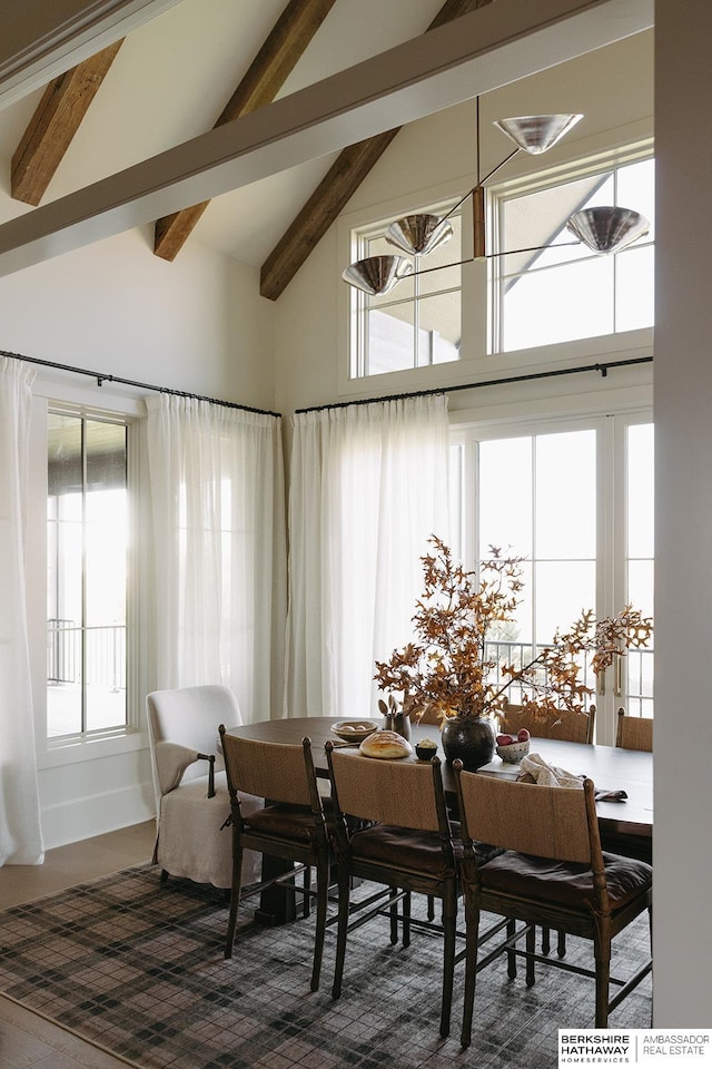 dining room with beamed ceiling and high vaulted ceiling