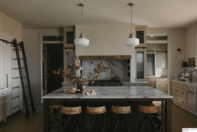 kitchen with backsplash, stove, light stone countertops, dark wood-type flooring, and hanging light fixtures