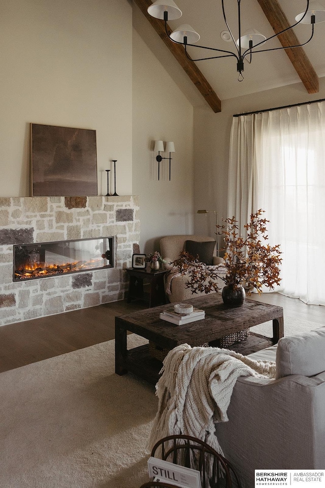 living area with a fireplace, wood finished floors, vaulted ceiling with beams, and an inviting chandelier