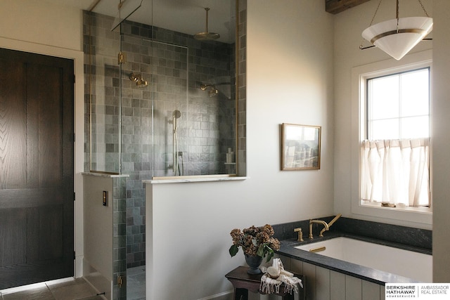 bathroom featuring a shower stall and a bath