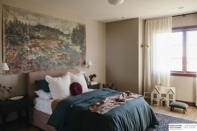 bedroom featuring visible vents and wood finished floors