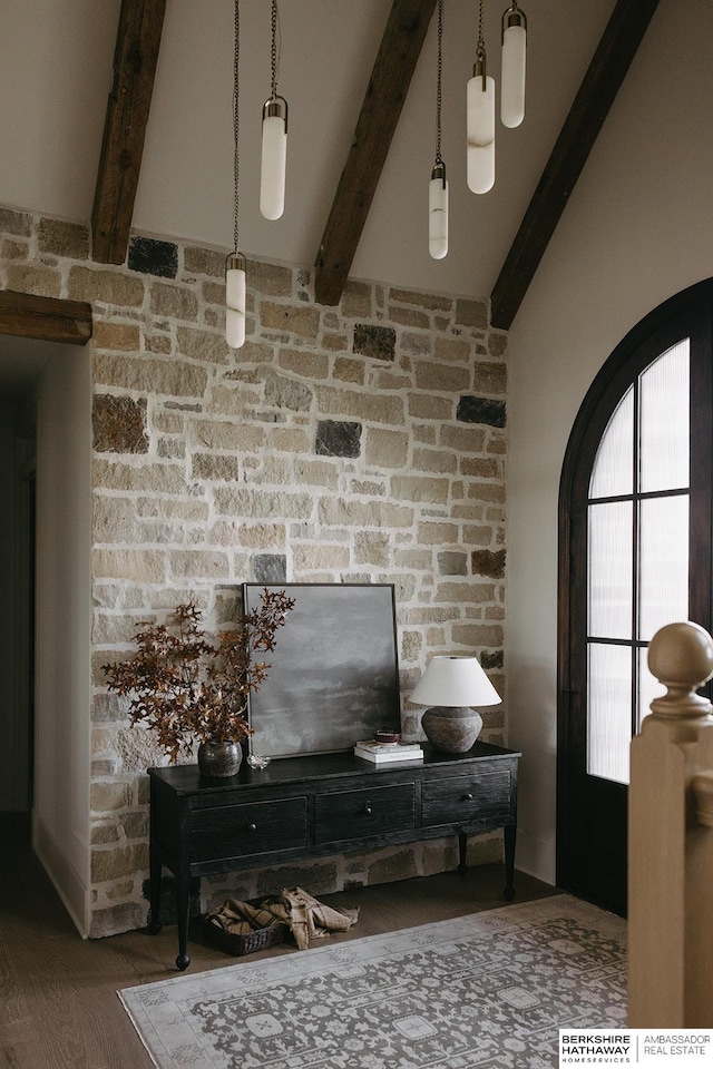 interior space featuring beamed ceiling, arched walkways, and wood finished floors