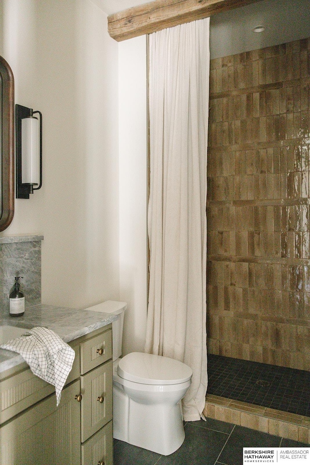 full bath with vanity, a tile shower, toilet, and tile patterned flooring