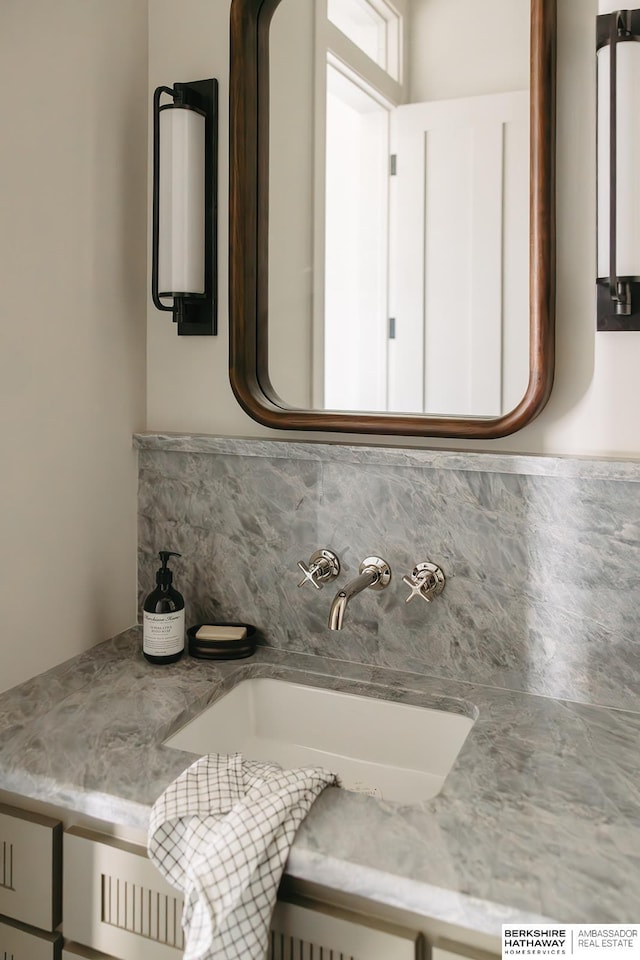 bathroom featuring decorative backsplash and a sink