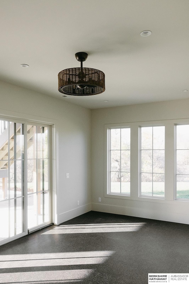 unfurnished room with recessed lighting, plenty of natural light, and baseboards