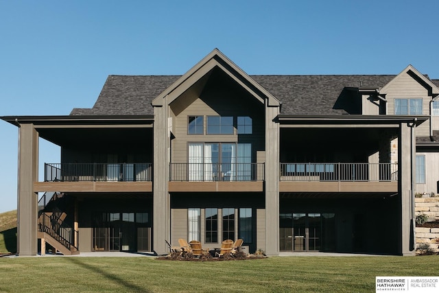 back of property featuring stairs, a yard, a balcony, and a shingled roof