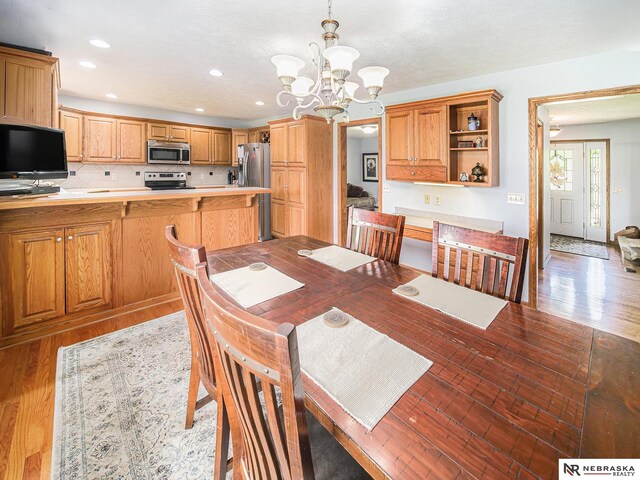 dining room featuring a chandelier, light wood finished floors, and recessed lighting