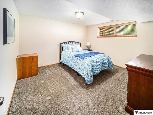 carpeted bedroom with baseboards, a textured ceiling, and vaulted ceiling
