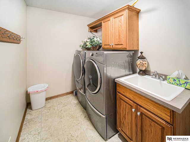 laundry room with washer and clothes dryer, cabinet space, baseboards, and light tile patterned floors