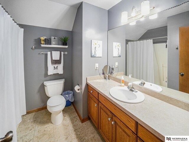 bathroom featuring lofted ceiling, baseboards, toilet, vanity, and tile patterned floors