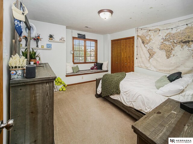 bedroom with carpet, baseboards, and a closet