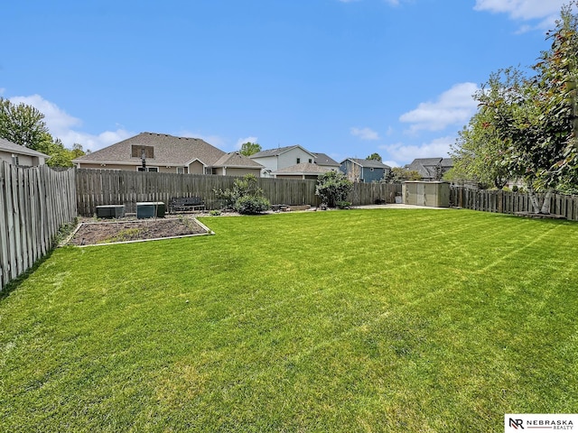 view of yard with central AC and a residential view