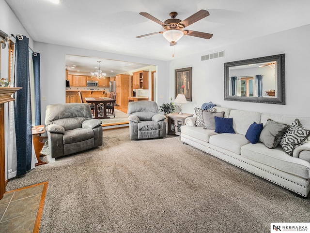 carpeted living area with a chandelier and ceiling fan