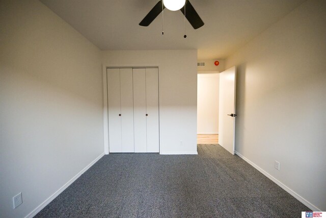 4915 Walker Ave, Lincoln, NE 68504 - unfurnished bedroom featuring dark carpet, a closet, baseboards, and a ceiling fan