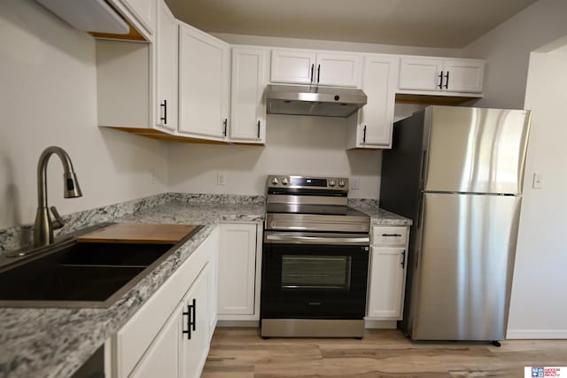 4915 Walker Ave, Lincoln, NE 68504 - kitchen featuring stainless steel appliances, a sink, under cabinet range hood, white cabinets, and light wood finished floors