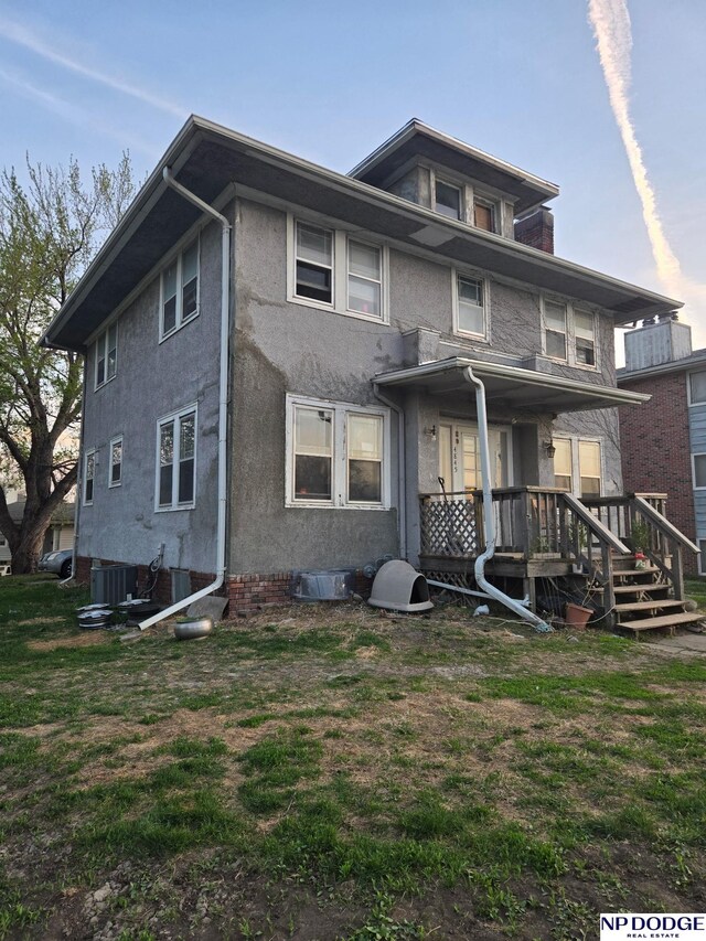 rear view of property with stucco siding and cooling unit