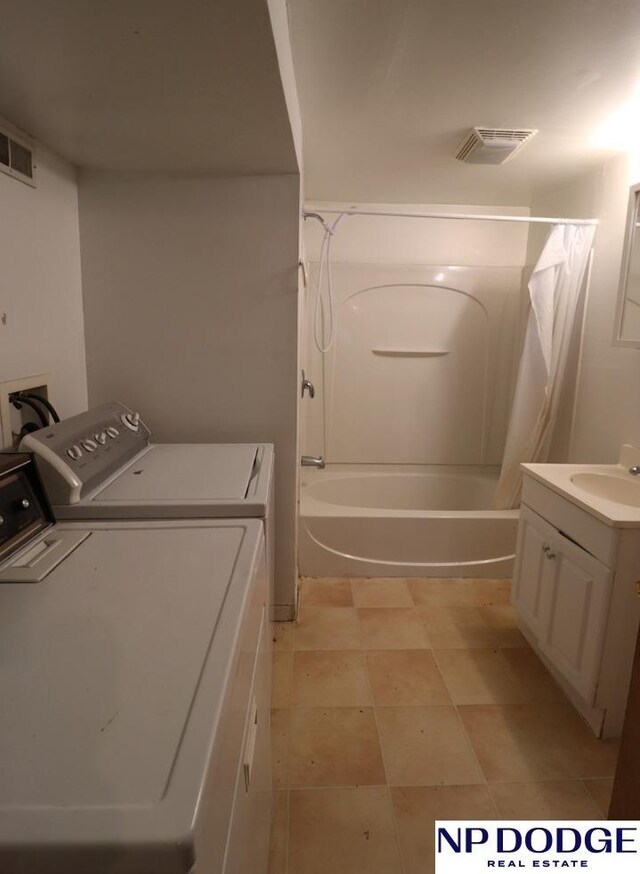 laundry area featuring washing machine and dryer, visible vents, a sink, and laundry area