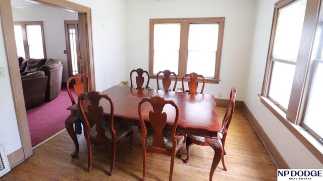 dining area with baseboards, wood finished floors, and plenty of natural light
