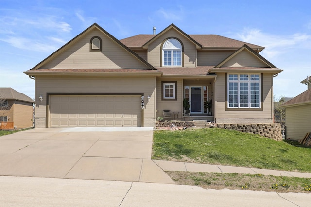 traditional-style house featuring a garage, driveway, and a front lawn