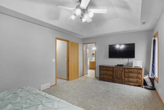 bedroom with baseboards, visible vents, carpet, and a tray ceiling