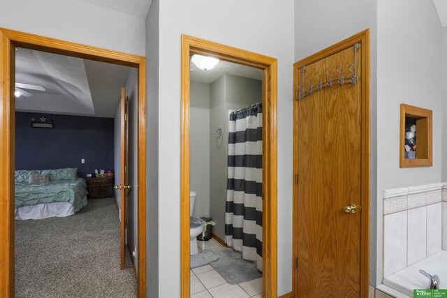 bathroom with ensuite bath, a ceiling fan, tile patterned floors, and toilet