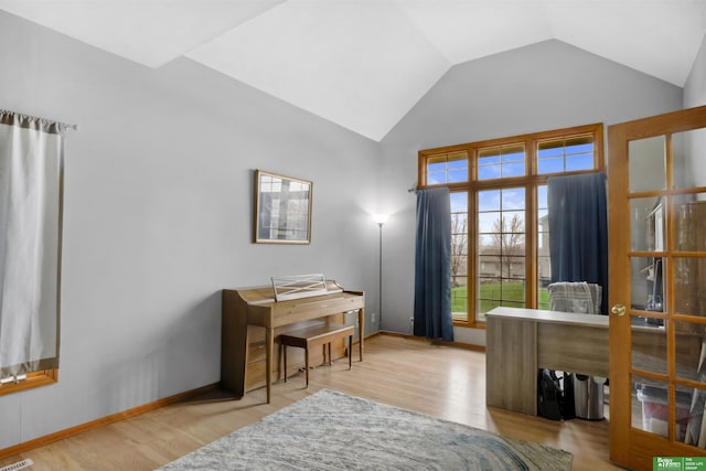 home office featuring lofted ceiling, baseboards, and wood finished floors