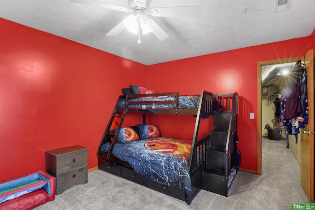carpeted bedroom with baseboards, visible vents, a spacious closet, and ceiling fan