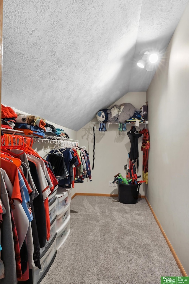 walk in closet with lofted ceiling and carpet floors