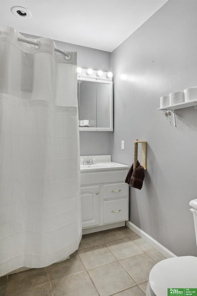 full bathroom with toilet, vanity, tile patterned floors, and baseboards