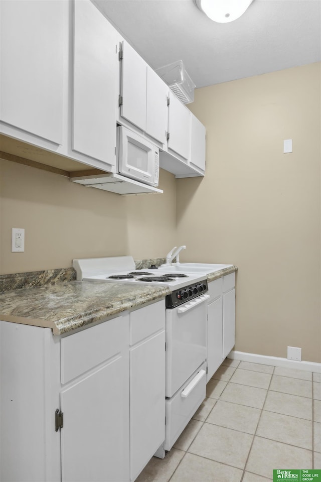 kitchen featuring white cabinets, baseboards, light tile patterned floors, and white appliances