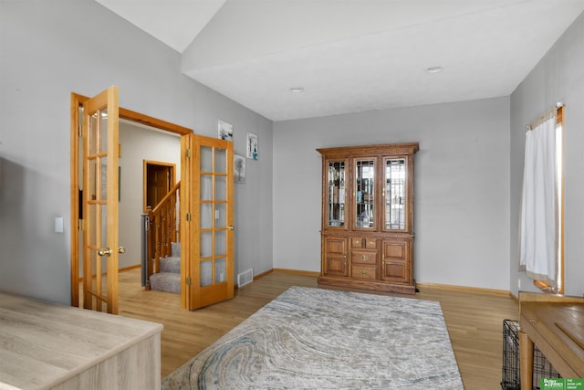 foyer entrance featuring baseboards, wood finished floors, visible vents, and stairs