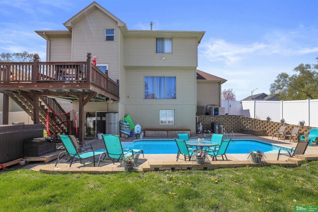 rear view of property featuring a patio area, a fenced backyard, a fenced in pool, and a deck