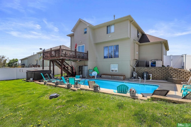 rear view of house with a fenced backyard, a wooden deck, a hot tub, stairs, and a patio
