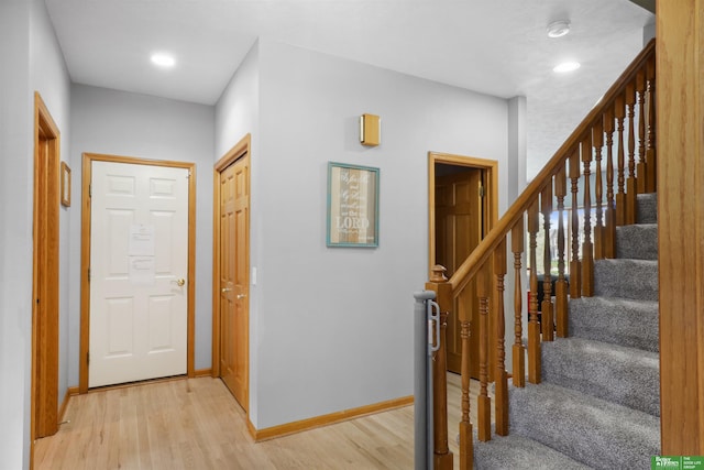interior space with baseboards, stairs, light wood finished floors, and recessed lighting