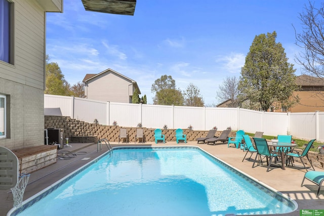 view of swimming pool with a patio area, a fenced backyard, a fenced in pool, and outdoor dining space