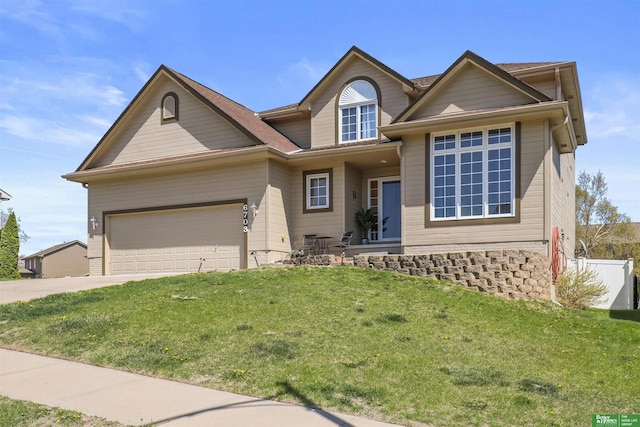 traditional home featuring concrete driveway, a front lawn, and an attached garage