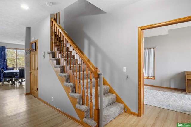 stairway with baseboards and wood finished floors