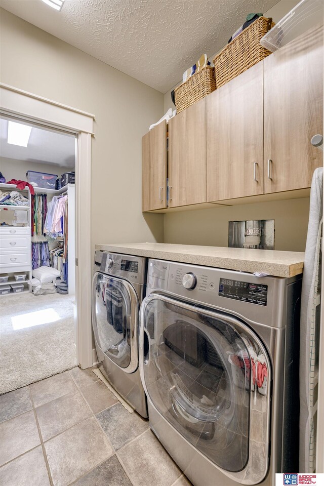 4510 W High Ridge Pl, Lincoln, NE 68522 - clothes washing area featuring a textured ceiling, cabinet space, washing machine and clothes dryer, and light colored carpet