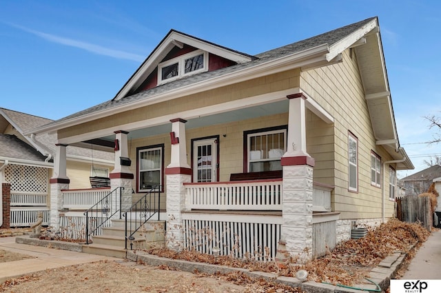 craftsman house featuring a shingled roof and covered porch