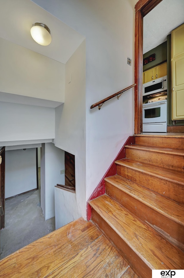 stairs featuring unfinished concrete flooring
