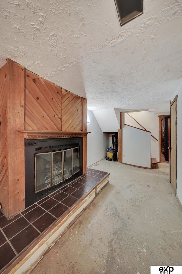 interior space with a tile fireplace and a textured ceiling
