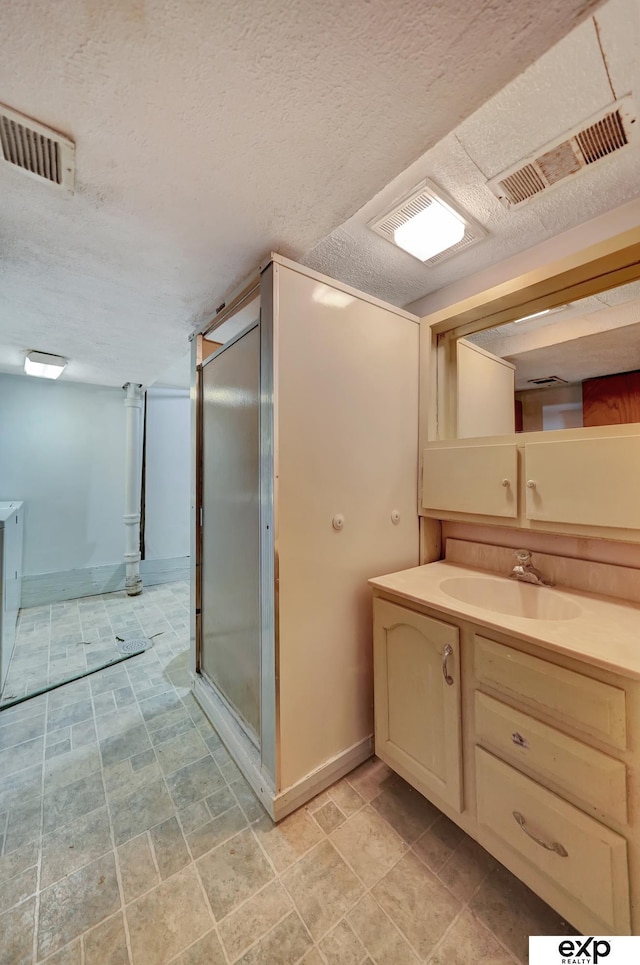 full bathroom featuring baseboards, a shower stall, visible vents, and vanity