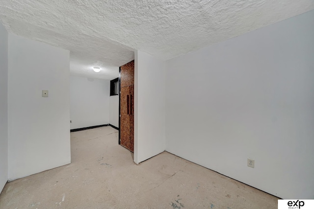 empty room featuring a textured ceiling and unfinished concrete flooring