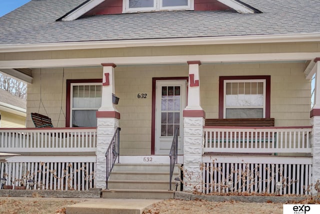 property entrance featuring a shingled roof and covered porch