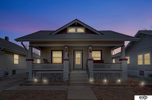 bungalow featuring covered porch and roof with shingles
