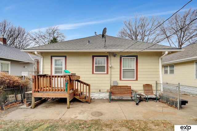back of property with a patio area, roof with shingles, and a fenced backyard