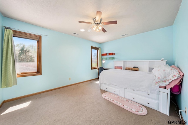 carpeted bedroom featuring baseboards, visible vents, and ceiling fan