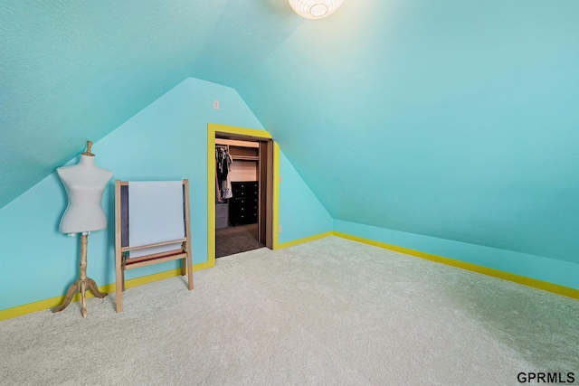 additional living space with vaulted ceiling, baseboards, carpet floors, and a textured ceiling