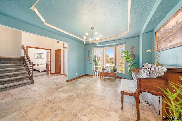 living area with stairs, a textured ceiling, a raised ceiling, baseboards, and a notable chandelier